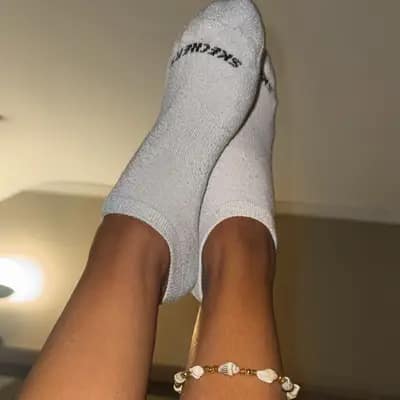 Graue Skechers-Socken – Hochgehaltene Beine & Muschel-Fußkettchen