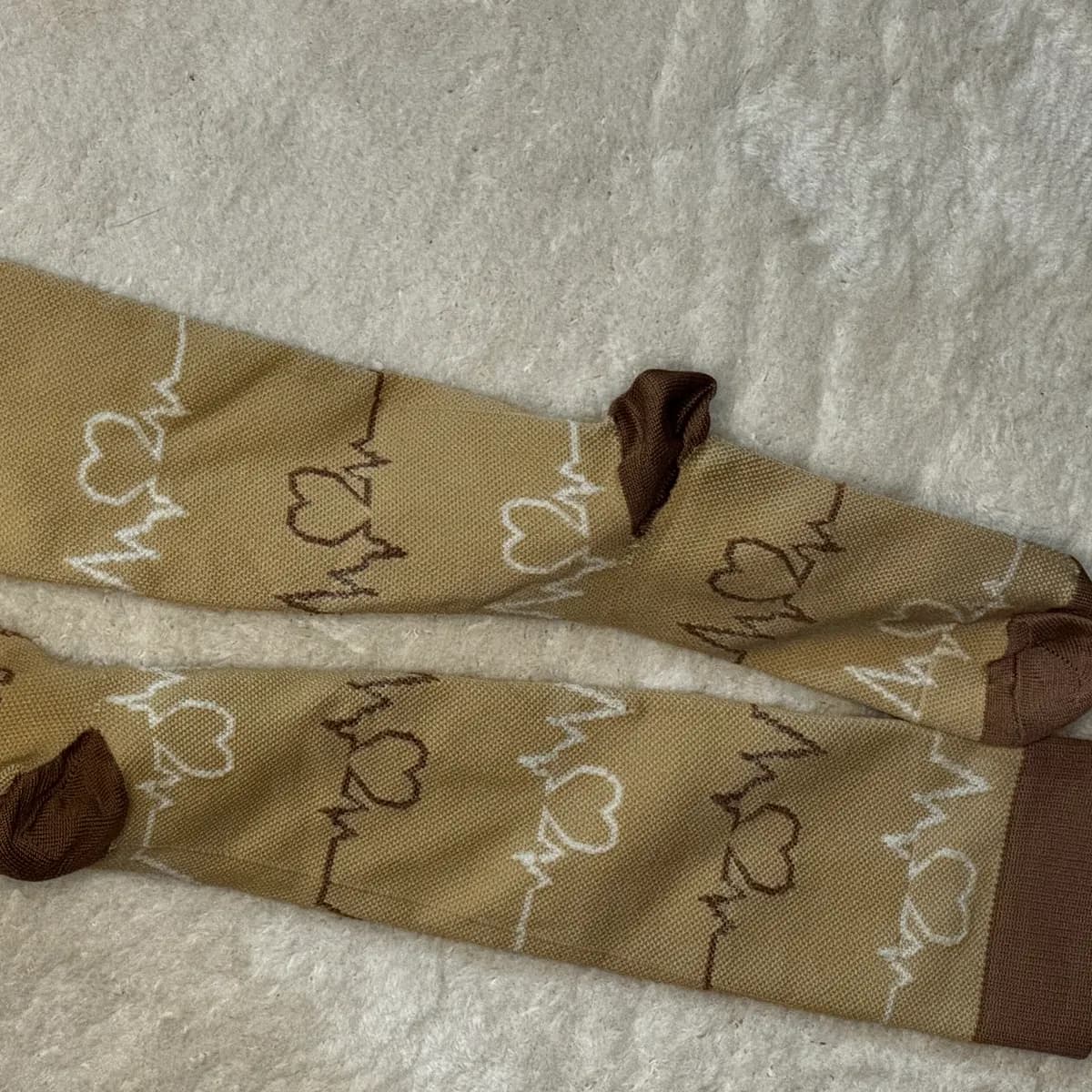 EKG-Herzen auf Beige – lange Socken, gepflegte Zehennägel
